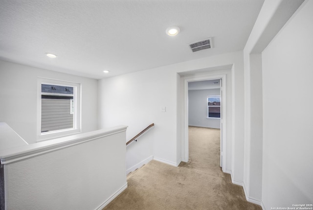 hall with light colored carpet