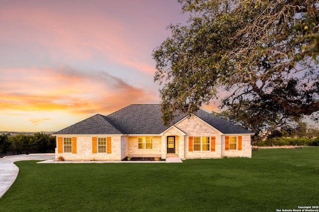 ranch-style home featuring a lawn