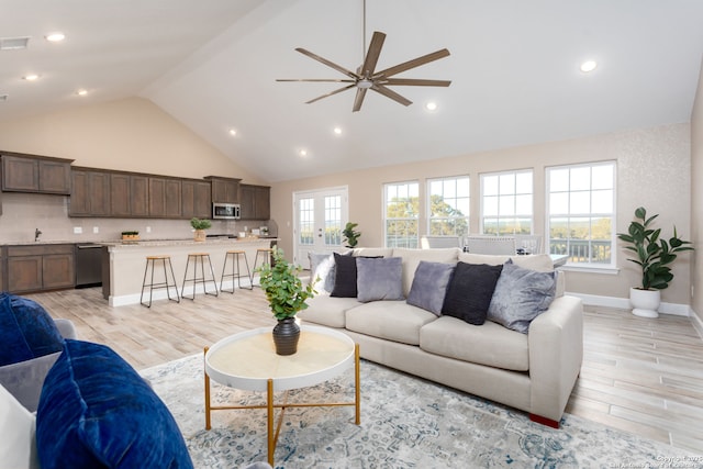 living room featuring ceiling fan, french doors, high vaulted ceiling, and light hardwood / wood-style floors