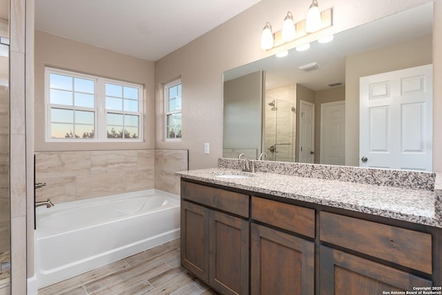 bathroom featuring separate shower and tub and vanity