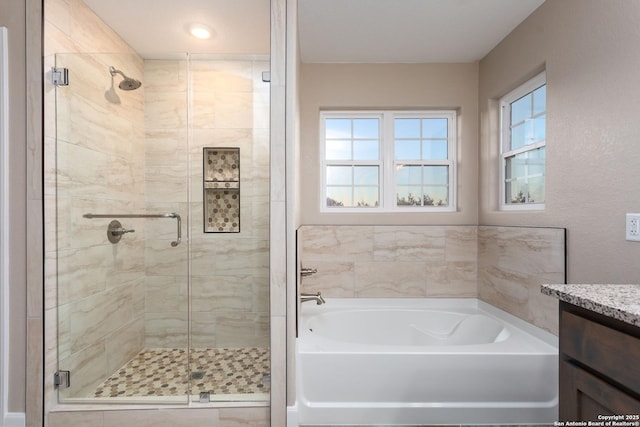 bathroom with vanity and independent shower and bath