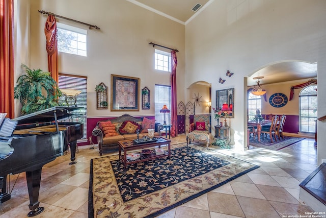 tiled living room featuring a high ceiling and crown molding