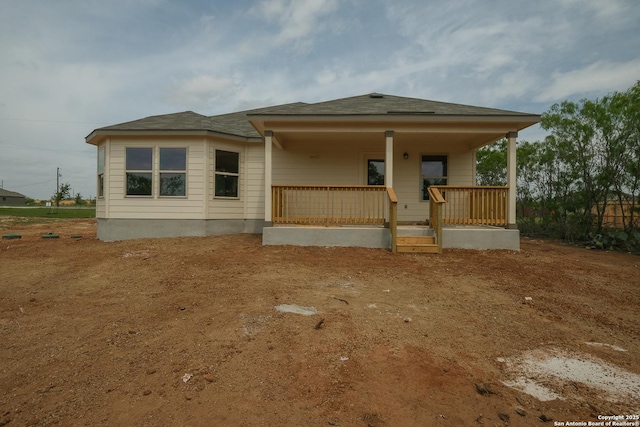 rear view of property featuring covered porch