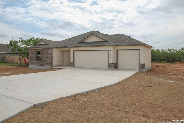 ranch-style home with brick siding, fence, concrete driveway, and an attached garage