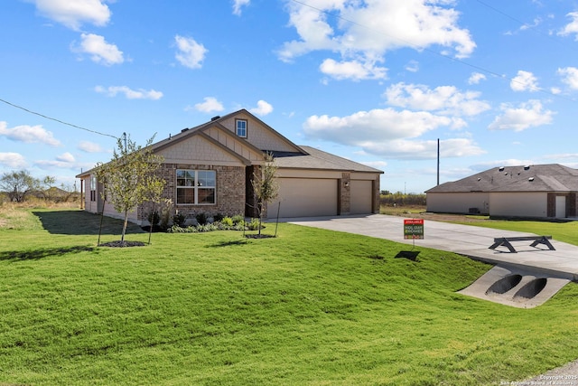 view of front of house featuring a garage, a front yard, concrete driveway, and brick siding