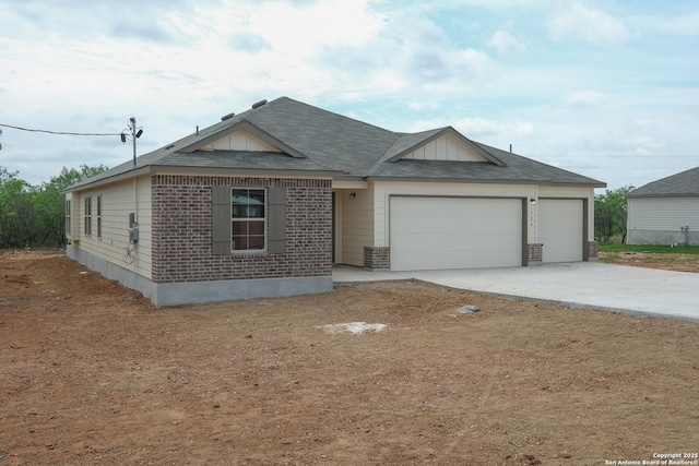 single story home featuring concrete driveway, a garage, and brick siding