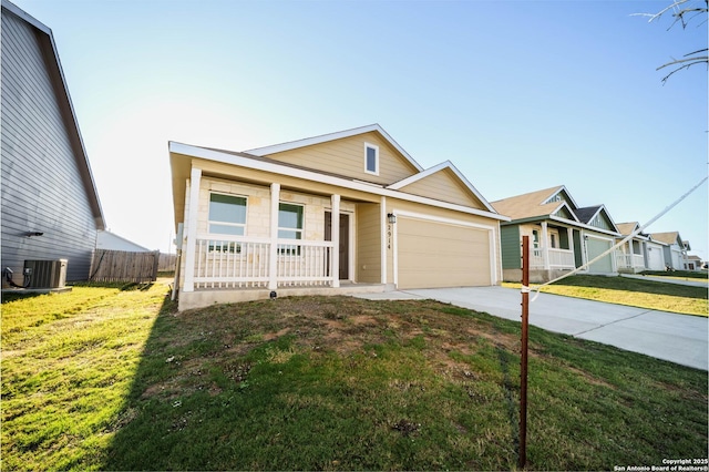 ranch-style home with cooling unit, a garage, covered porch, and a front lawn