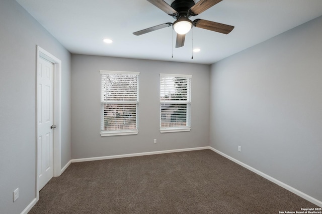 empty room with dark colored carpet and ceiling fan