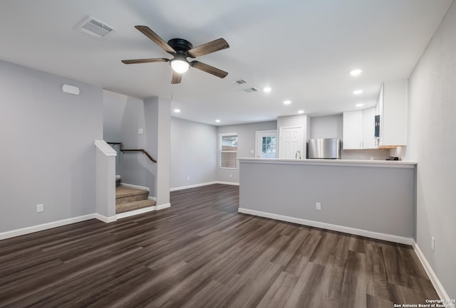 unfurnished living room with ceiling fan and dark hardwood / wood-style flooring