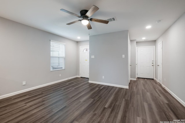 spare room featuring ceiling fan and dark wood-type flooring