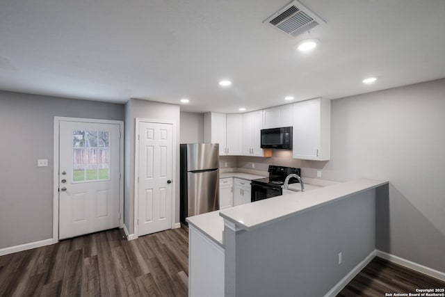 kitchen with white cabinets, dark hardwood / wood-style flooring, kitchen peninsula, and black appliances