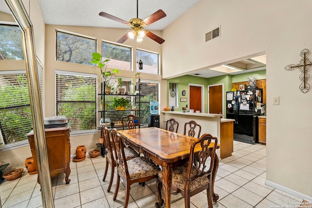 dining room with vaulted ceiling, ceiling fan, light tile patterned floors, and a textured ceiling