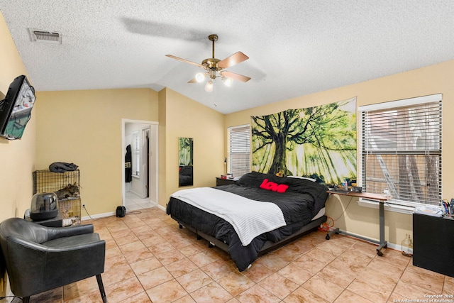 tiled bedroom featuring ceiling fan, lofted ceiling, ensuite bathroom, and multiple windows