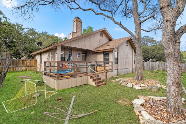 back of property with a yard and a wooden deck