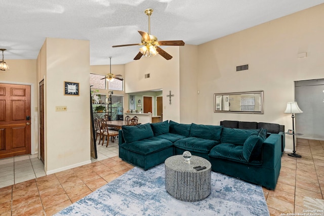 living room featuring ceiling fan, light tile patterned floors, a textured ceiling, and high vaulted ceiling