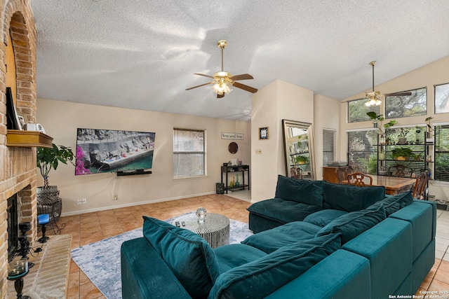 living room with ceiling fan, light tile patterned floors, a fireplace, and vaulted ceiling