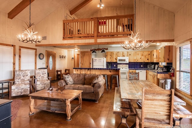 tiled dining space with wood walls, beam ceiling, high vaulted ceiling, and a chandelier