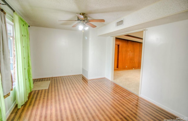 carpeted spare room with a textured ceiling and ceiling fan