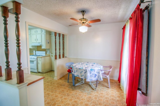 dining area featuring ceiling fan and a textured ceiling