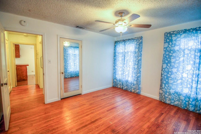 spare room featuring wood-type flooring, a textured ceiling, and ceiling fan