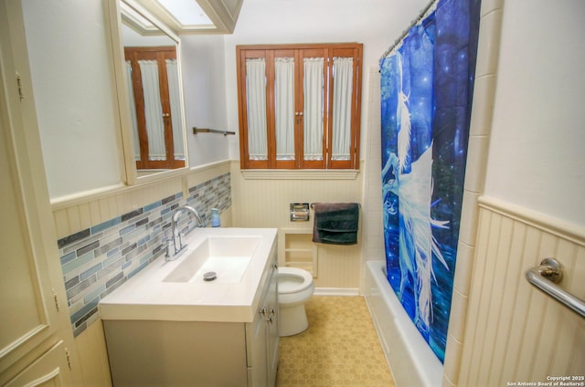 full bathroom featuring toilet, shower / bathtub combination with curtain, and vanity