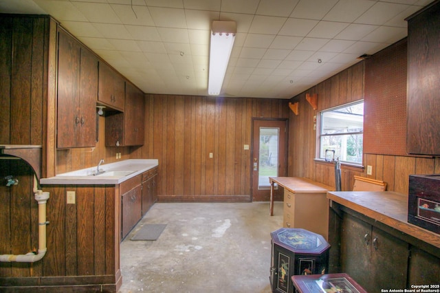 kitchen with sink, wooden walls, and butcher block countertops