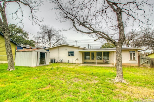 rear view of property featuring a patio area, central AC unit, a storage shed, and a yard