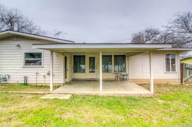 back of property with a patio and a yard