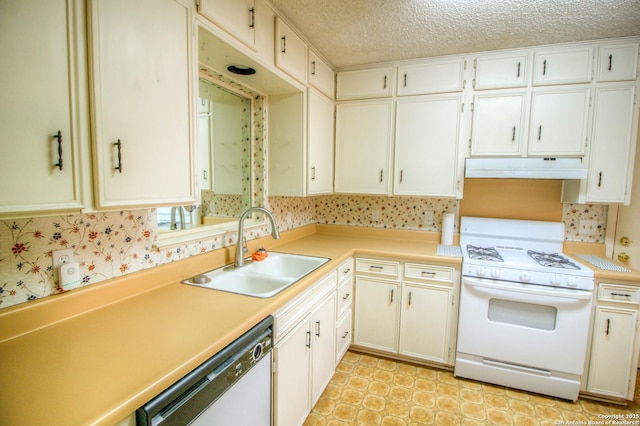 kitchen featuring white appliances, white cabinets, a textured ceiling, and sink