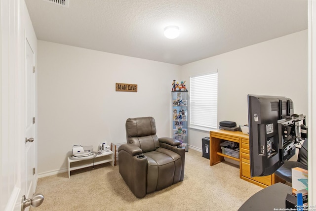 carpeted home office featuring a textured ceiling