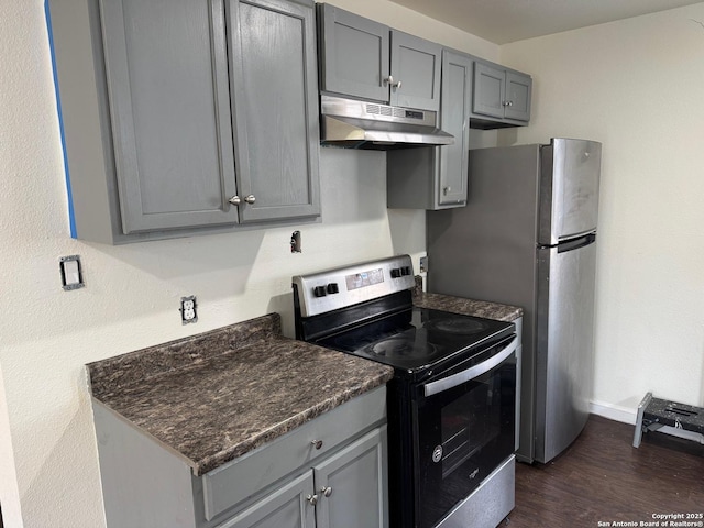 kitchen with appliances with stainless steel finishes, dark hardwood / wood-style floors, and gray cabinetry