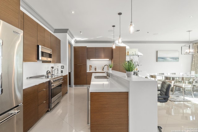 kitchen featuring pendant lighting, sink, light tile patterned floors, and stainless steel appliances