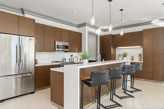 kitchen featuring pendant lighting, a kitchen island with sink, a breakfast bar area, light tile patterned floors, and stainless steel appliances