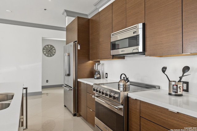 kitchen with light tile patterned floors, high quality appliances, and sink