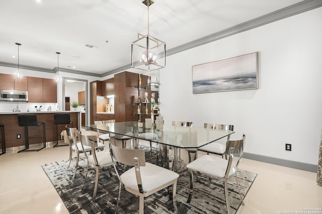 dining area featuring light tile patterned floors, ornamental molding, and a notable chandelier