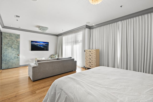 bedroom with crown molding and hardwood / wood-style flooring