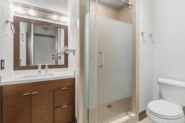 bathroom featuring vanity, toilet, and an enclosed shower