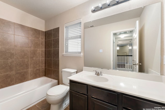 full bathroom featuring tile patterned floors, vanity, tiled shower / bath combo, and toilet