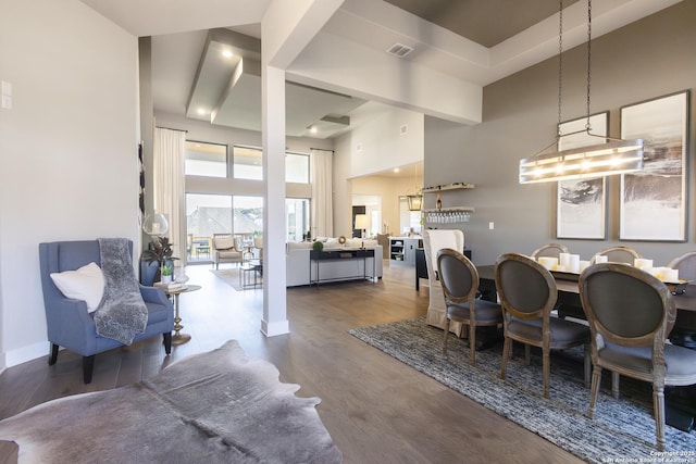 dining room featuring a towering ceiling and hardwood / wood-style flooring