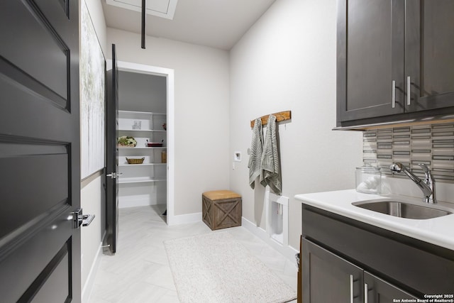 clothes washing area featuring cabinets and sink