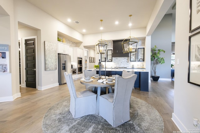 dining space featuring light hardwood / wood-style floors and a notable chandelier