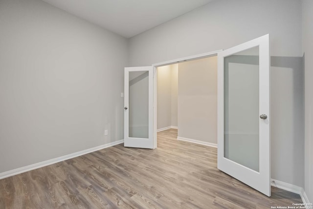 unfurnished bedroom with french doors and light wood-type flooring