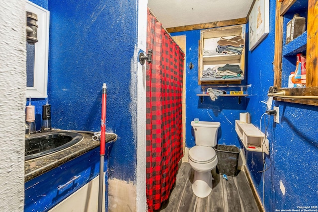 bathroom featuring hardwood / wood-style floors, vanity, toilet, and a textured ceiling