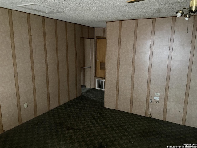 spare room featuring carpet flooring and a textured ceiling