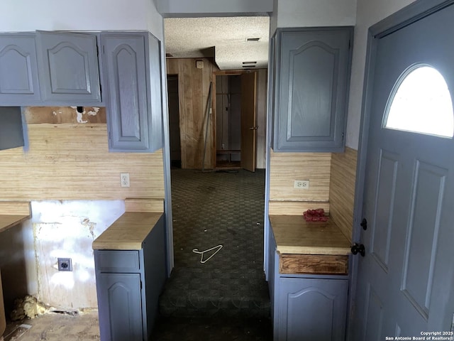 kitchen featuring a textured ceiling and backsplash