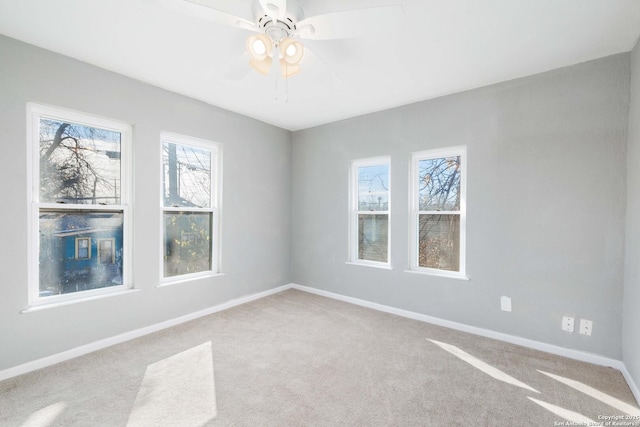 carpeted empty room featuring a wealth of natural light and ceiling fan