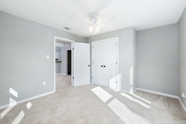 unfurnished bedroom with light carpet, a closet, and ceiling fan