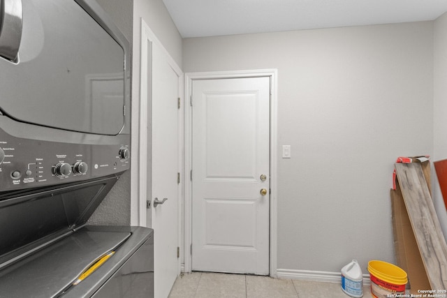 laundry area featuring light tile patterned flooring and stacked washer and clothes dryer