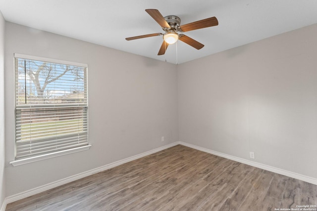 empty room featuring ceiling fan, plenty of natural light, and wood-type flooring