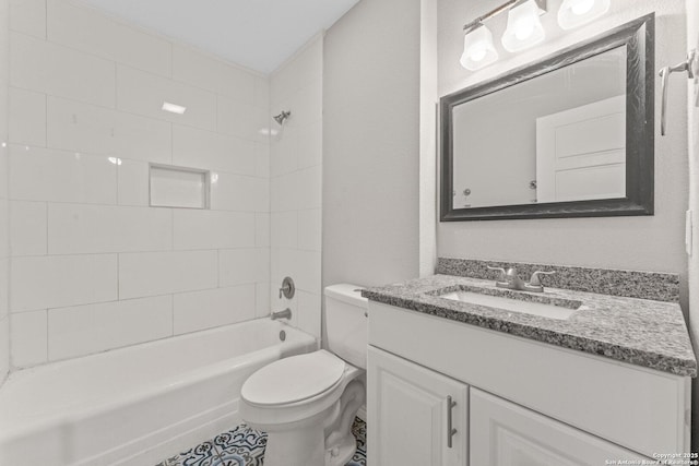 full bathroom featuring vanity, tiled shower / bath, and toilet